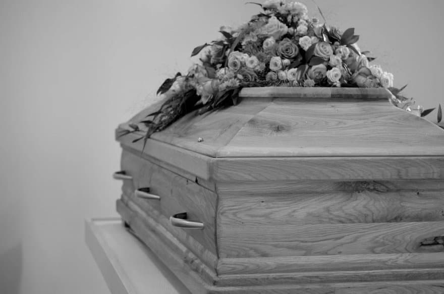 Ataúd con arreglo floral, el peso emocional de recibir el cuerpo equivocado